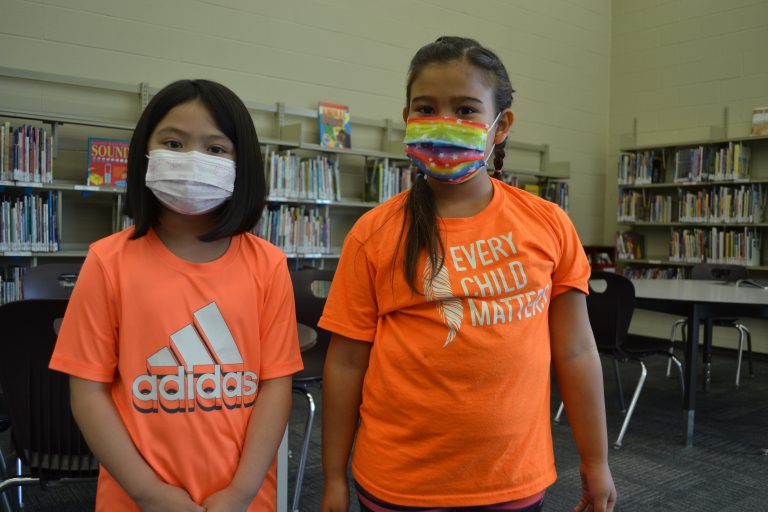 two girls wearing orange