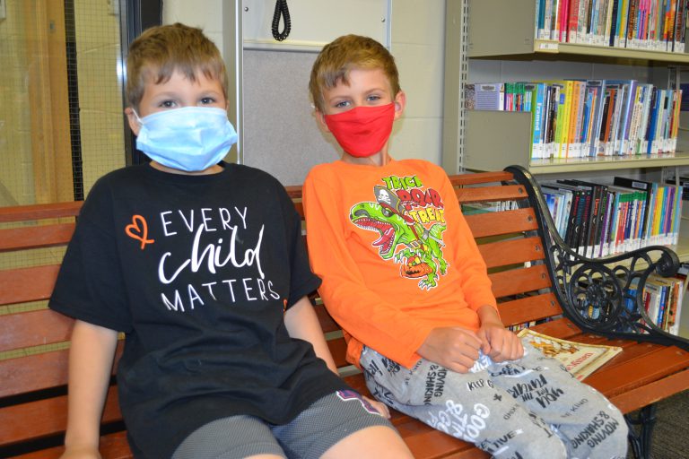 two boys wearing orange