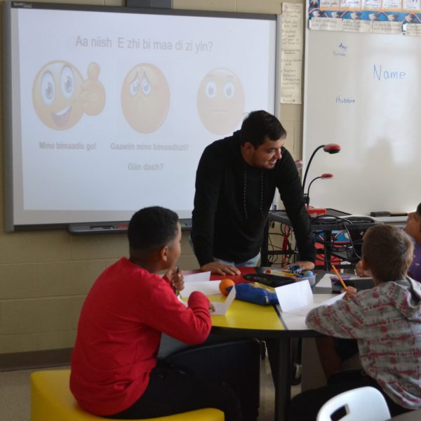 indigenous students talk with educational assistant