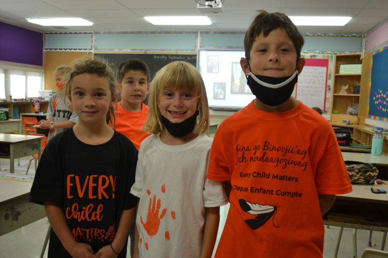 three students in orange