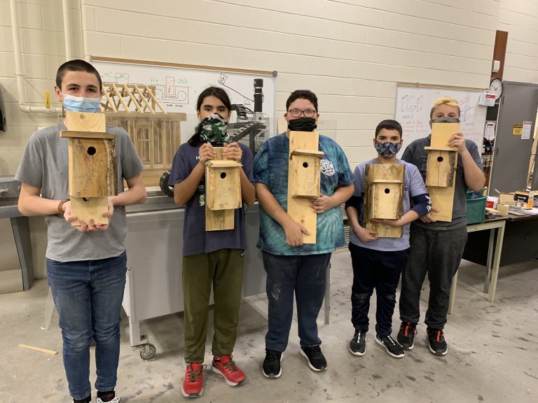 five students with birdhouses