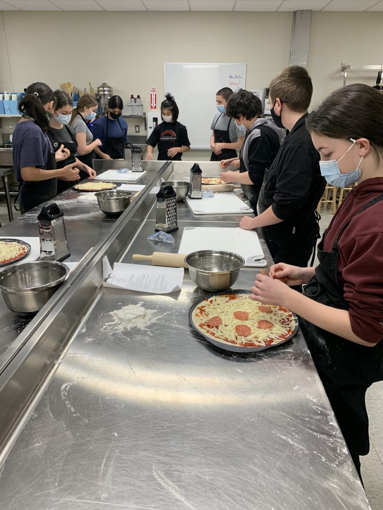 students making pizzas