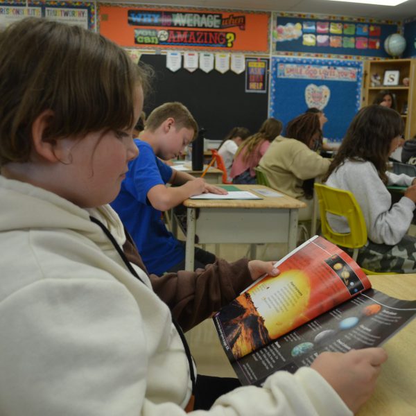 student reading a book in classroom