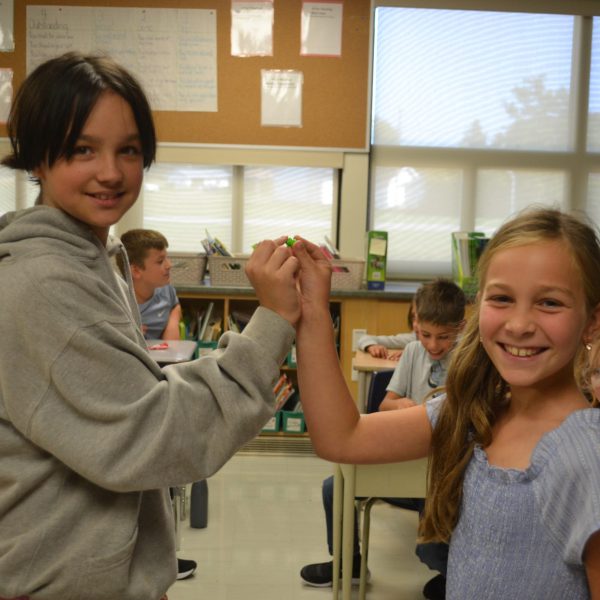 two students do a toast with skittles