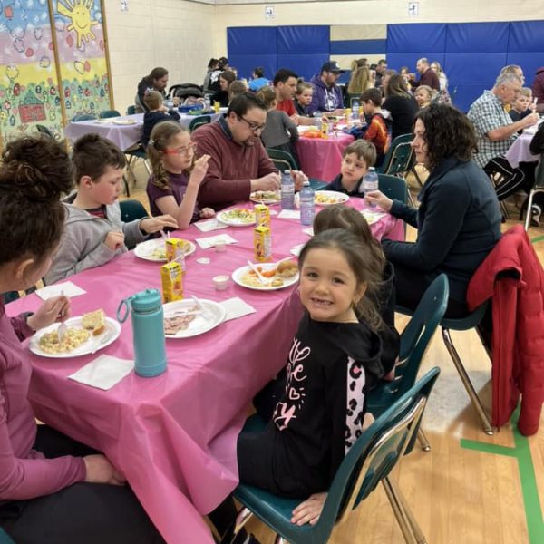 Families gather for a feast in the gymnasium