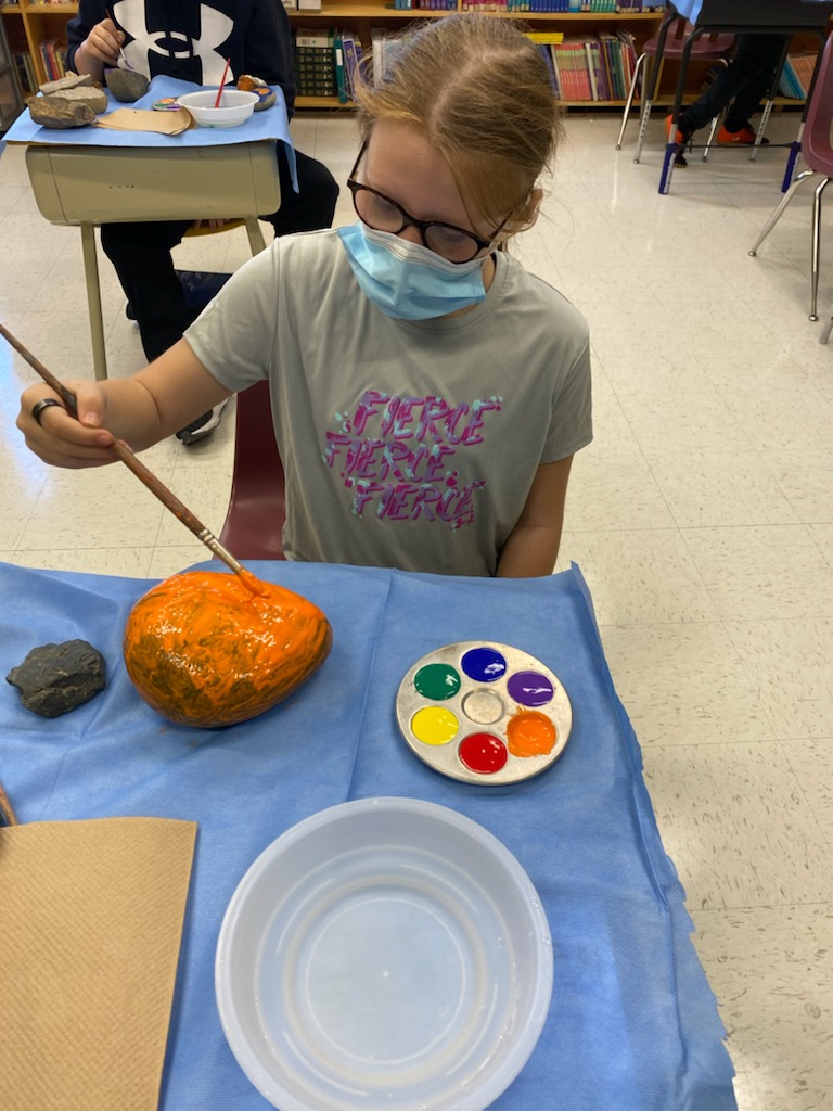 student painting her rock
