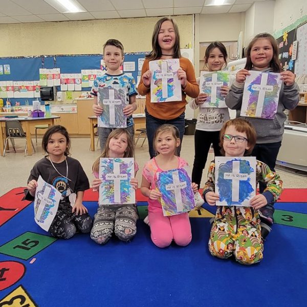 Students hold up artwork for Easter celebration