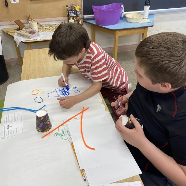 Students work on art at a table