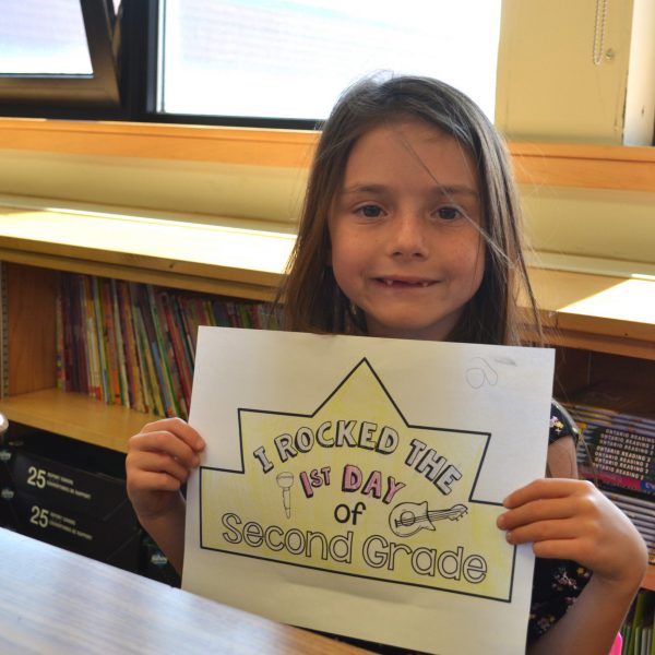 female student holding sign saying I rocked the first day of second grade