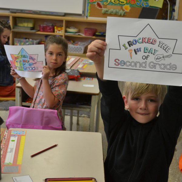 student holding sign saying I rocked the first day of second grade