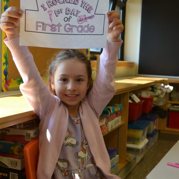 student holds sign over her head saying i rocked the first day of first grade