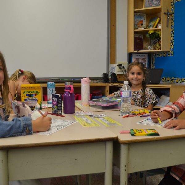 three students colouring at their desks