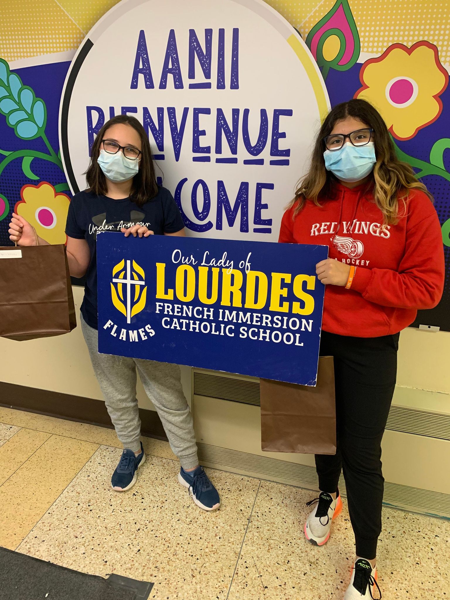 students holding school sign