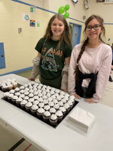 Female students with tray of cupcakes