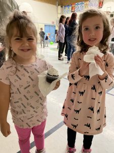 Two females students eating cupcakes