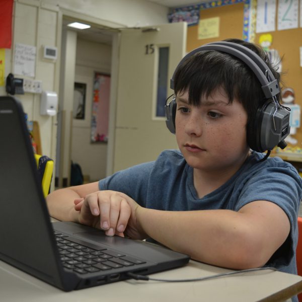 Student wears headphones while on computer