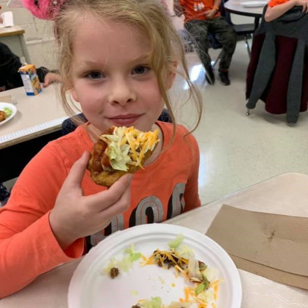 student eating indian taco