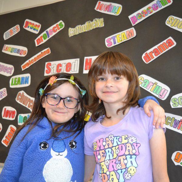 Two girls in front of bulletin board