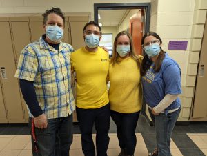 four staff members in yellow and blue