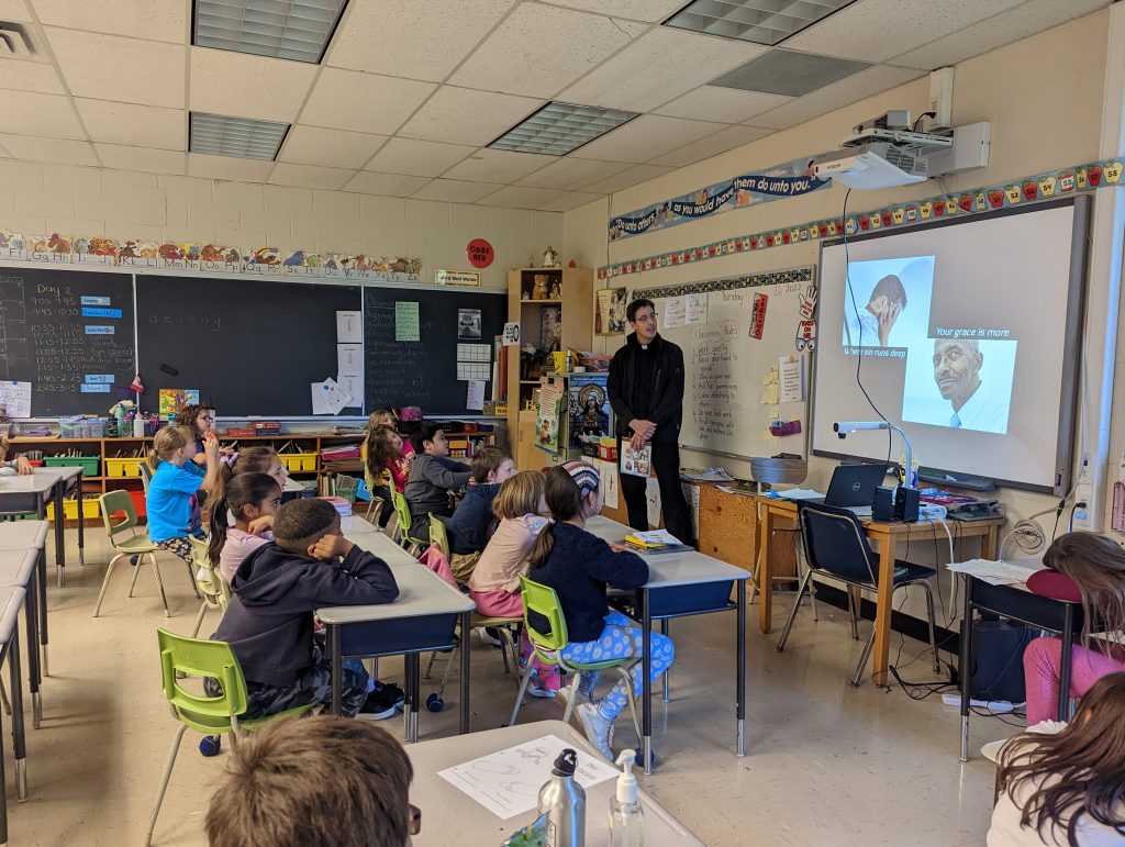 Father Shannon shows video to students