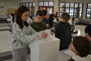 Female students puts ballot in box