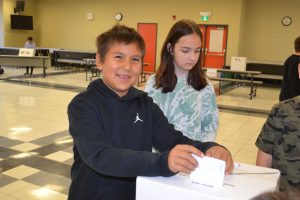 Student puts ballot in box