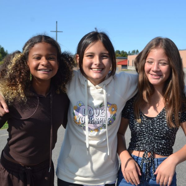 three students smile for the camera