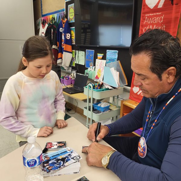 Former NHL player Jason Simon signs an authograph for students