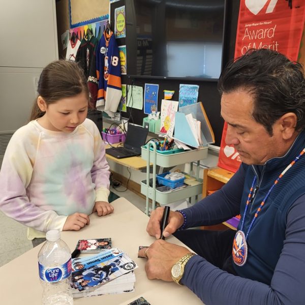 Former NHL player Jason Simon signs an authograph for students