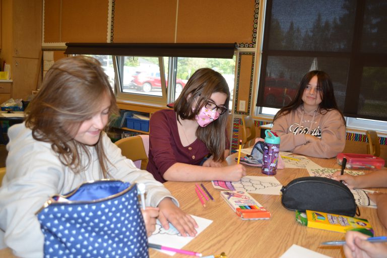 female students colouring at table