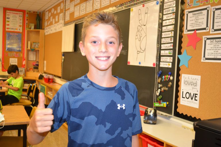 male student gives a thumbs up sign