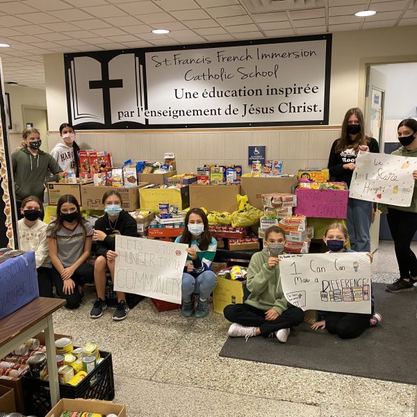 students posing in front of food items.