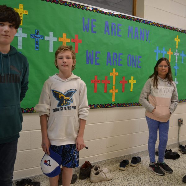 Four students in front of bulletin board with school-year theme