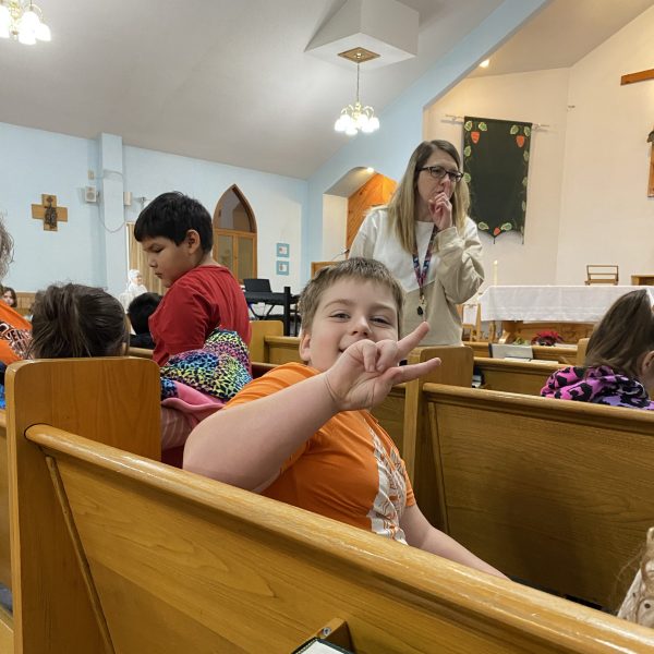 Student gives the peace side prior to a mass