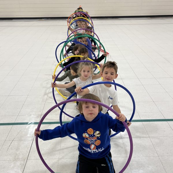 Students in gymnasium with hula hoops