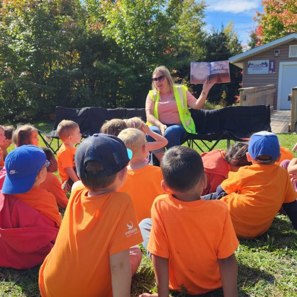 Teacher shows book to students during reading on Orange Shirt Day