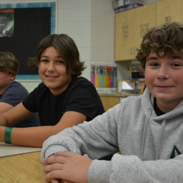 three students sitting at their desks
