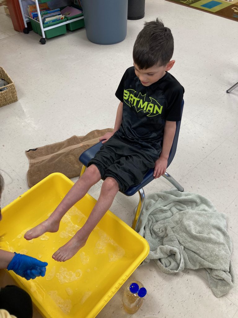 boy preparing to have feet washed