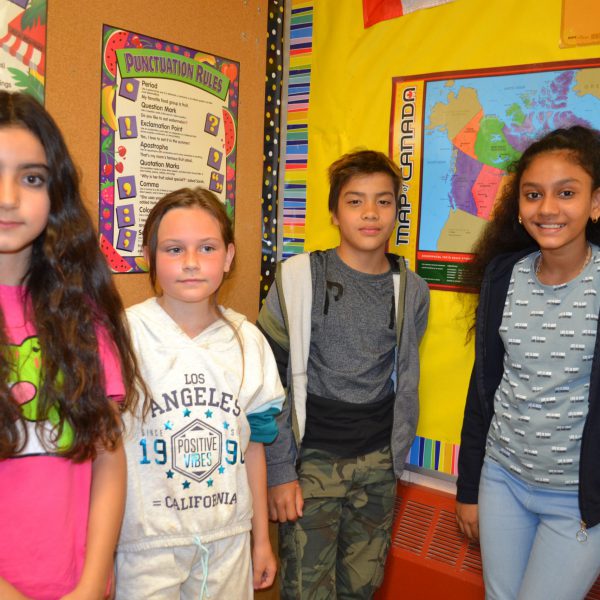 four students in front of bulletin board