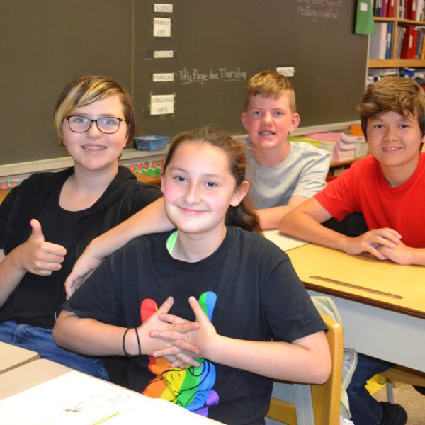 four students sitting at their desks