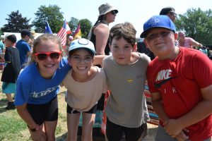 Four students pose for a photo at the Indigenous Day Pow Wow