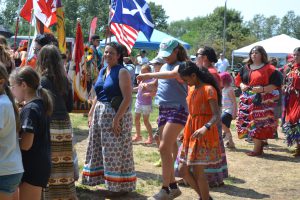 Lina DiPasquale in dancing circle with students at Indigenous Day Pow Wow